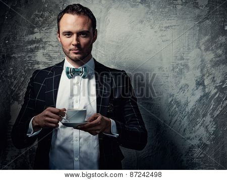 Sharp dressed fashionist with cup of coffee