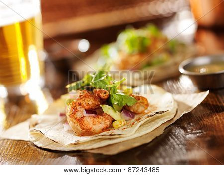 spicy shrimp avocado tacos in slanted composition