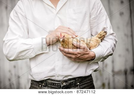 Farmer Holding A Beige Chicken