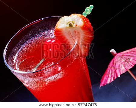 Strawberry  cocktail  with cherry and umbrella in highball glass . Top view.