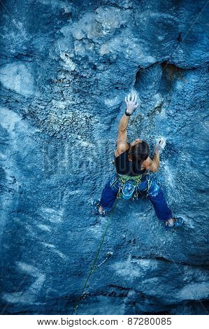 Rock climber climbing up a cliff