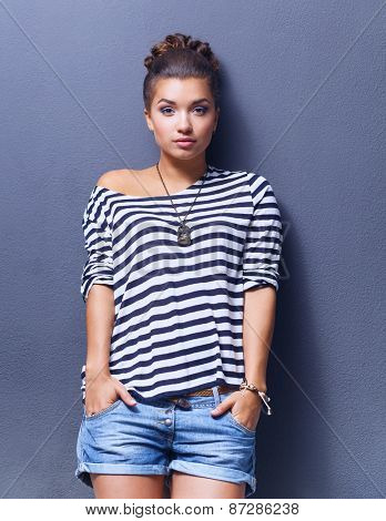 A young woman standing, isolated on graybackground