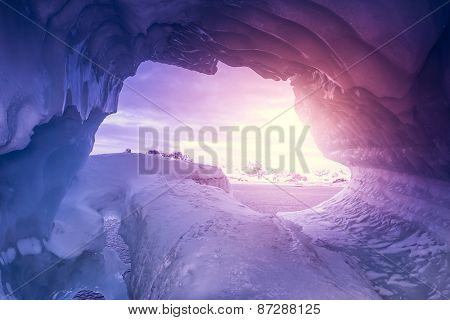 Violet ice cave covered with snow and flooded with light. Antarctica. Vernadsky Research Base.