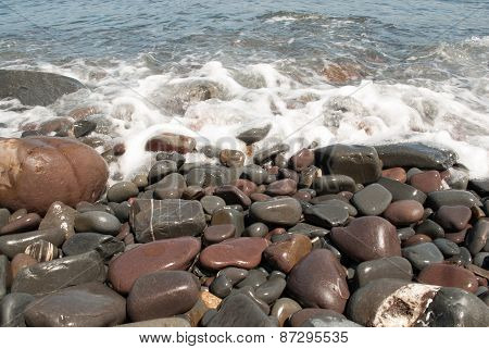 Pebbles on the Beach Being Washed by Wave