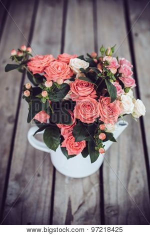 Bouquet of roses in vintage coffee pot