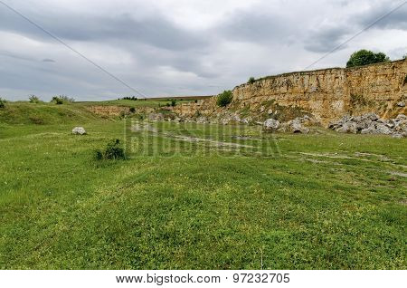 General view toward crag of sedimentary rock in the field