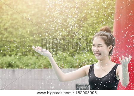Portrait of Asian girl with waterfall at the pool. Happiness smling. copy space.