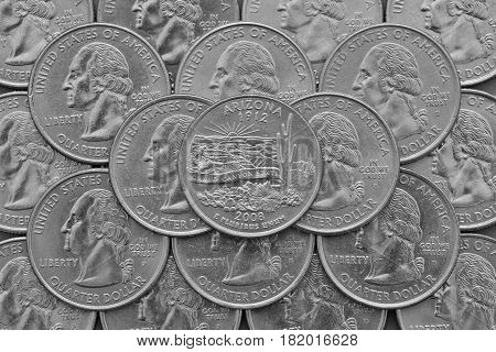 Arizona State and coins of USA. Pile of the US quarter coins with George Washington and on the top a quarter of Arizona State.