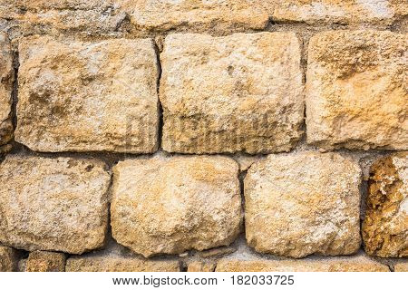 Background wall made of stone. Fragment of a wall from a chipped stone