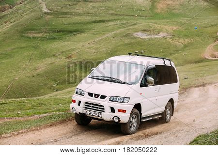 Stepantsminda Gergeti, Georgia - May 23, 2016: Mitsubishi Delica Space Gear on country road in summer mountains landscape. Delica is a range of trucks and multi-purpose vehicles produced by Mitsubishi Motors.