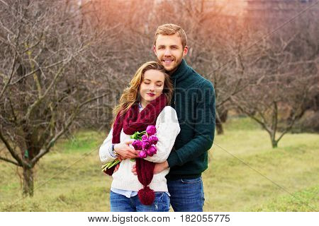 Happy Together. Portrait Of Bearded Man Standing Behind His Girlfriend And Hugging Her. Beautiful Sm