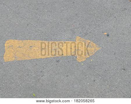 Road surface with yellow arrow sign outdoor symbol going forward left to right abstract photo