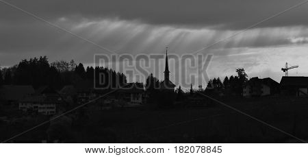 Sunbeams over a small church. Sign of hope.