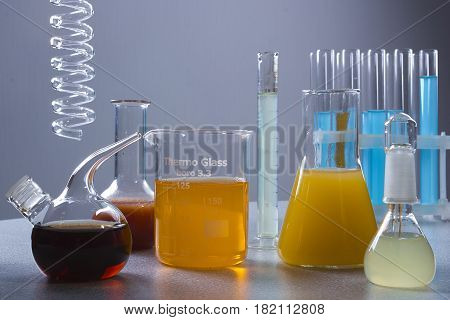 Multicolored liquids in laboratory glassware on a gray background