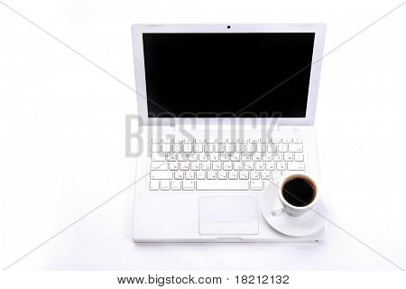Taza de negro caliente humeante café en un ordenador portátil