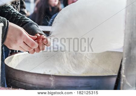 Close up male hands making white floss candy