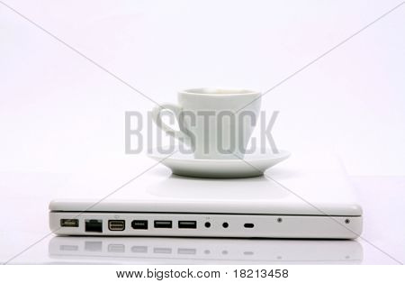 Taza de negro caliente humeante café en un ordenador portátil