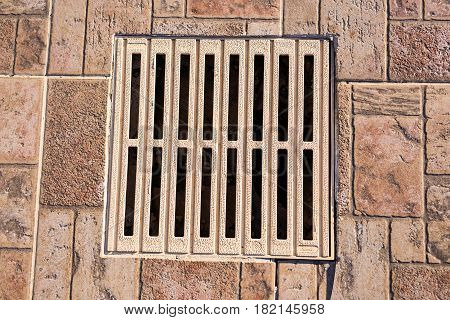 metal storm drain with water running into it.