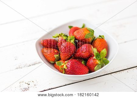 Freshly Handpicked Strawberries in a Bowl on White Wooden Table