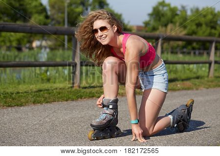 Roller skating sporty girl in park on inline skates. Caucasian woman in outdoor fitness activities.