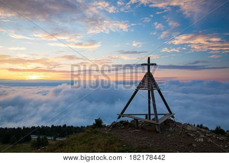 Wooden monument at sunrise. Gerlitzen Apls in Austria.
