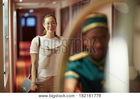 Young woman following after porter with her baggage