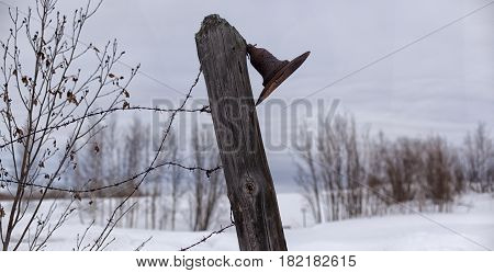 Old, Rusty Lantern On A Fence With Barbed Wire.