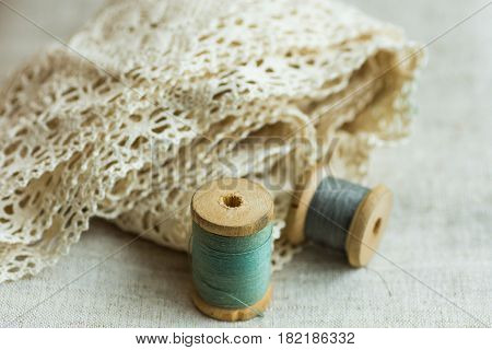 Vintage wood spools with green and grey threads on linen fabric cotton lace swing hobby concept copyspace website banner