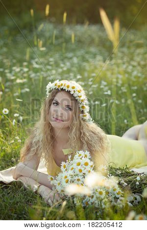Cute blond lady woman with curly hairs on camomile field