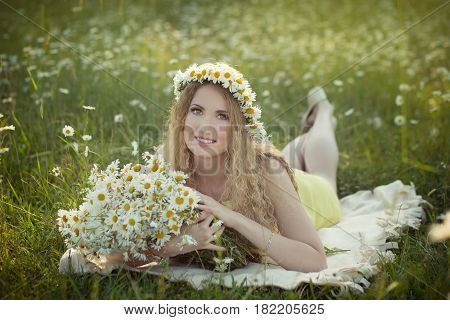 Cute blond lady woman with curly hairs on camomile field