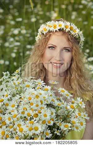 Cute blond lady woman with curly hairs on camomile field