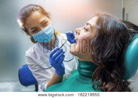 Dentist woman with patient. Stomatologist holding probe and mirror. Buy dental insurance.