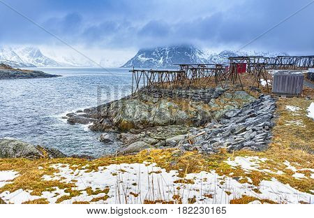 Travel Concepts and Ideas. Seashore Outskirt of Hamnoy Fishing Village With Wooden Constructions for Cod Drying in Norway.Horizontal Image Composition