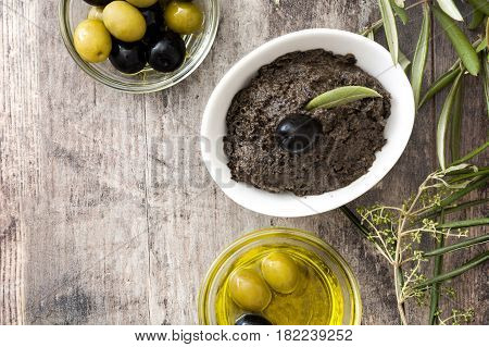 Black olive tapenade with anchovies, garlic and olive oil on wooden background
