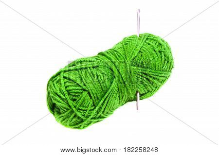 Green yarn clew with crochet hooks isolated on white background