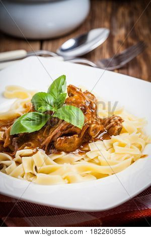 Tagliatelle with dark sauce. Italian cuisine. Selective focus.
