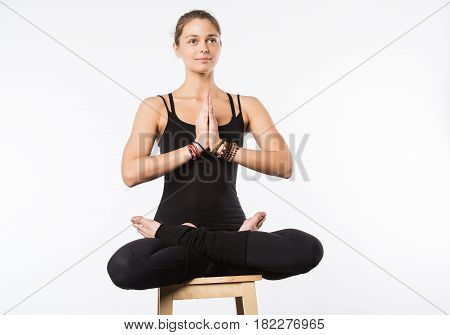 Sporty beautiful young woman sitting in Gomukhasana, Cowface pose, yin yoga Shoelace posture, asana for stretching hips and thighs, studio full length shot on white background, front view, isolated.