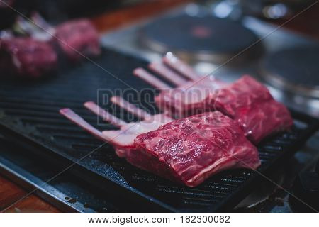 Different stages of cooking the steak on a kitchen, barbeque, roasted lamb ribs, big dish plate with roasted full pork head, served in restaurant with vegetables, lamb, ham and chicken.