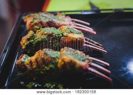 Different stages of cooking the steak on a kitchen, barbeque, roasted lamb ribs, big dish plate with roasted full pork head, served in restaurant with vegetables, lamb, ham and chicken.