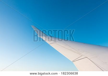 Looking through the window aircraft during flight a snow covered Italian and Osterreich Alps with blue sky without clouds.