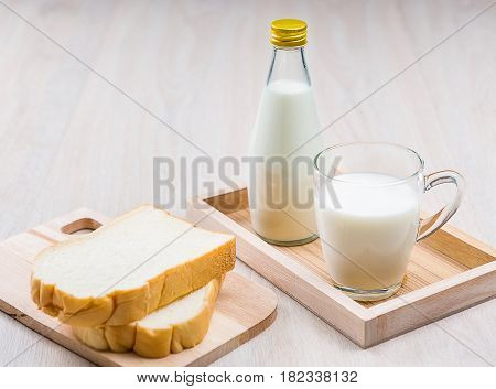 Breakfast with milk and sliced bread on the wooden table