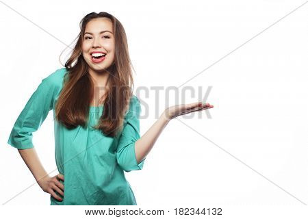 Young smiling woman points a hand with positive facial expressio