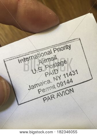 NYC - 16 APRIL 2017: International Priority Airmail US Postage PAID stamp on letter