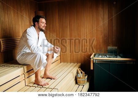 Handsome man relaxing in sauna and staying healthy