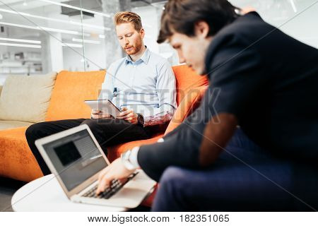 Bsuiness colleagues relaxing on sofa during break