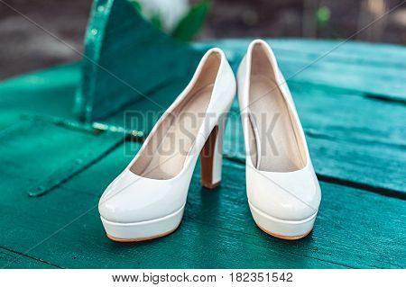 bride's biege shoes on heel on a wooden board tiffany colour.