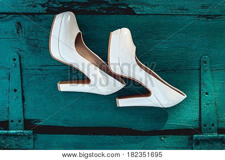 bride's biege shoes on heel on a wooden board tiffany colour.