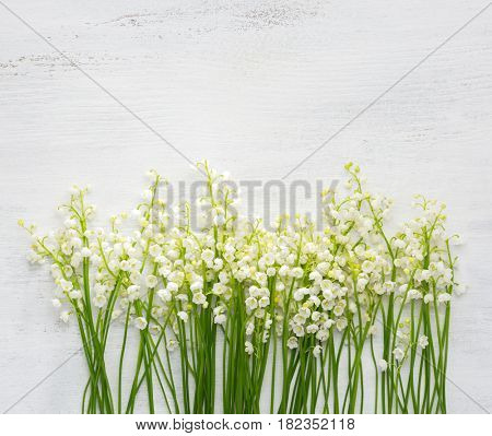 Lilies of the Valley on white shabby wooden background