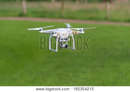 OLDENZAAL NETHERLANDS - JUNE 19 2016: DJI Phantom drone with camera attached flying low above the grass