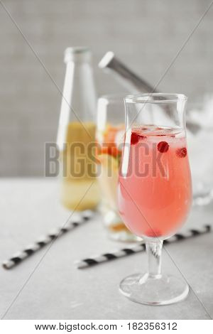 Glass of delicious wine spritzer on grey table